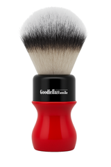 Makeup brush with red handle and black and white bristles on a white background