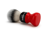 Shaving brush with red handle and black and white bristle head on a white background