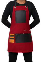 Red apron with black and orange patches worn by a person on a white background