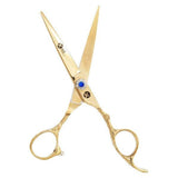 A pair of gold-colored hairdressing scissors with a dragon handle design and a large blue gemstone on the ring.